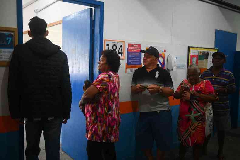 Eleitores aguardam para votar dentro de zona eleitoral na Rocinha