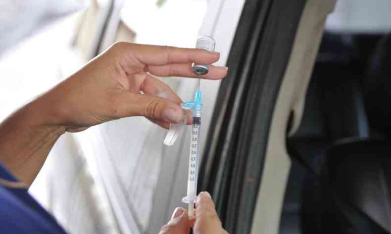 Enfermeira coloca vacina em seringa 