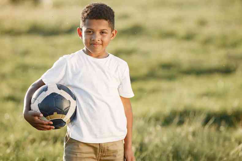 Menino negro segurando uma bola