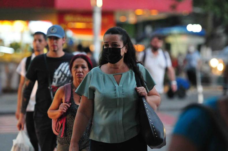 Pessoas atravessando a rua no centro de Belo Horizonte, apenas uma mulher est de mscara