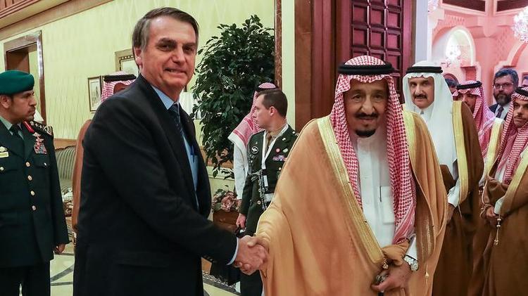 Bolsonaro e o rei apertando as mos e sorrindo contidamente