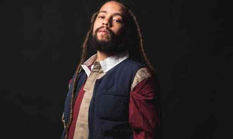 Jo Mersa Marley usa dreads no cabelo e barba; est com o semblante srio