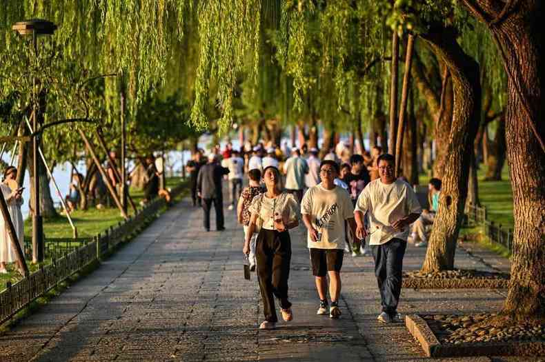Chineses caminham em parque em Zhejiang 