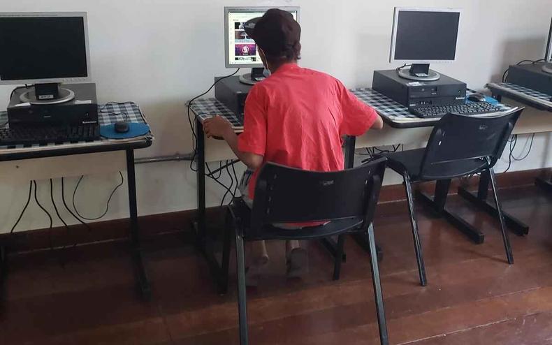 Jovem de costas, usando o computador