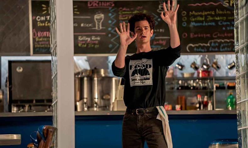 Andrew Garfield, com roupa de garom, ergue os braos em cena do filme 'Tick, Tick... Boom!'