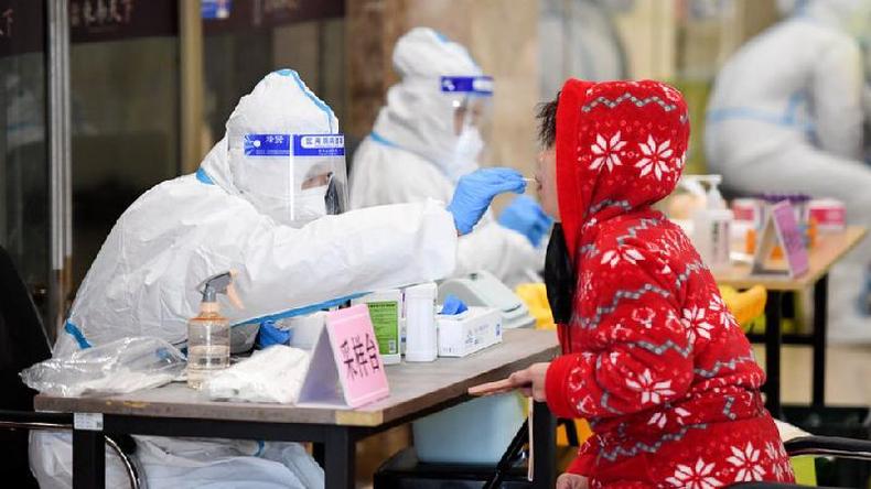 Um trabalhador mdico coleta uma amostra de um residente local para teste de cido nucleico COVID-19 em 13 de maro de 2022 em Changchun, provncia de Jilin, na China
