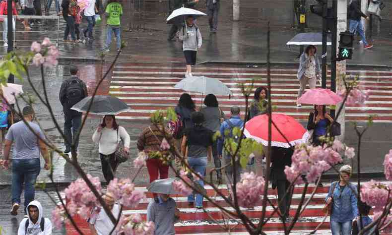 Munidos de guarda-chuvas, pedestres atravessam trecho da Afonso Pena. Em dia de primavera chuvoso e frio, cidade teve a menor temperatura mxima do ano, de 18,4C(foto: Jair Amaral/EM/D.A Press)