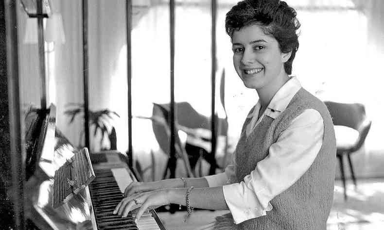 A cantora e compositora Celly Campello toca piano, sorrindo, em foto de 1961 