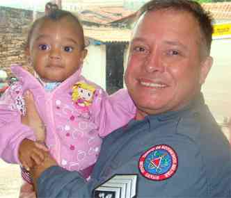 A pequena Camila com o sargento dos bombeiros Moiss Dias de Paula, que salvou a criana na noite de Natal(foto: Sargento Luciano/Divulgao Corpo de Bombeiros)