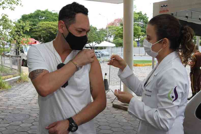 Enfermeira aplicando vacina de reforo em enfermeiro de Belo Horizonte