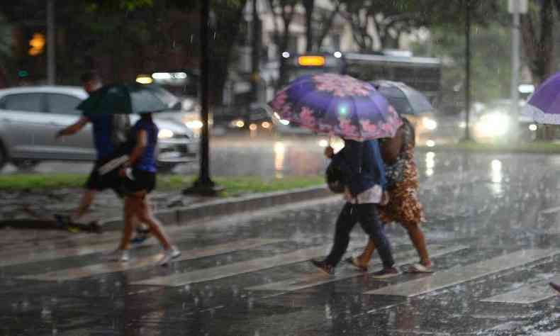 Imagem de pessoas andando na rua sob chuva