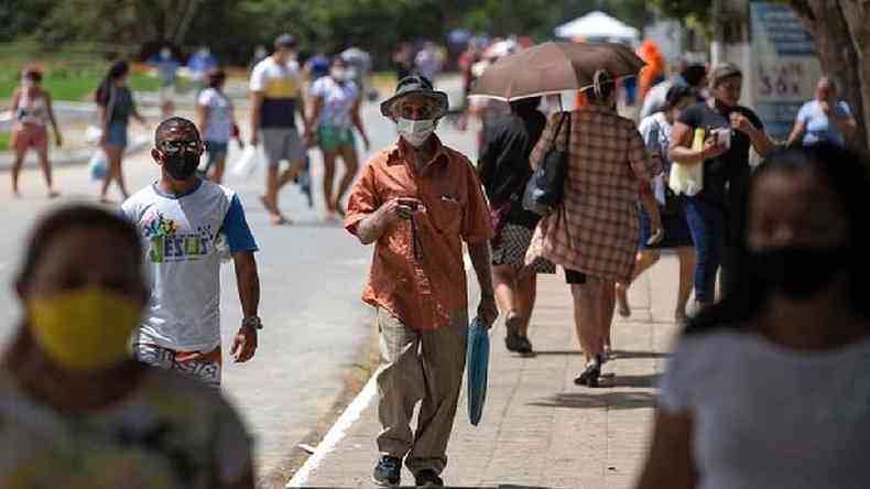 Pessoas caminham por rua de cidade brasileira