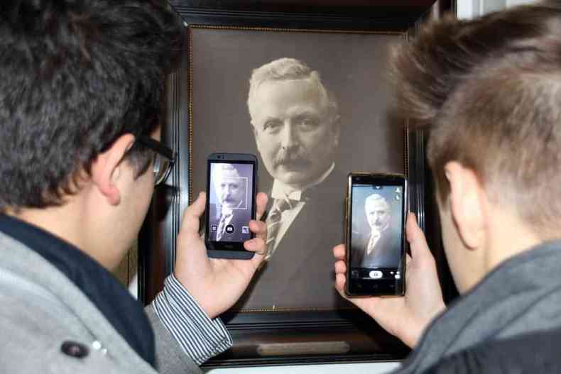 Jovens tiram foto de quadro com imagem de homem velho 