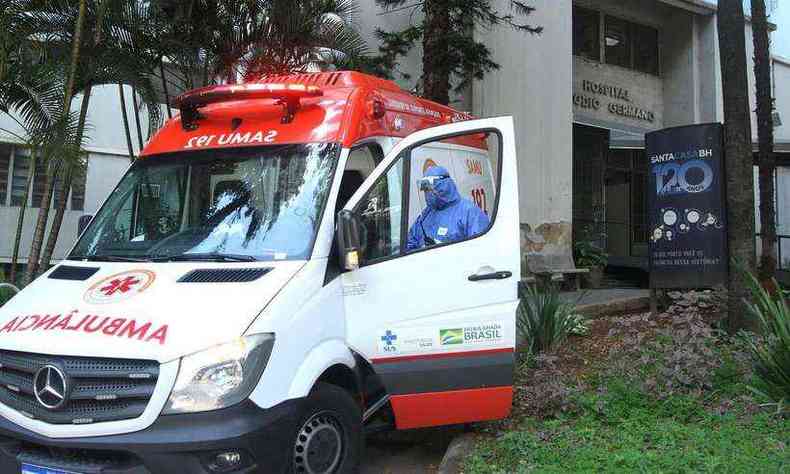 Com roupa de proteo, trabalhador da rea de sade entra em ambulncia em frente a portaria C da Santa Casa de Belo Horizonte