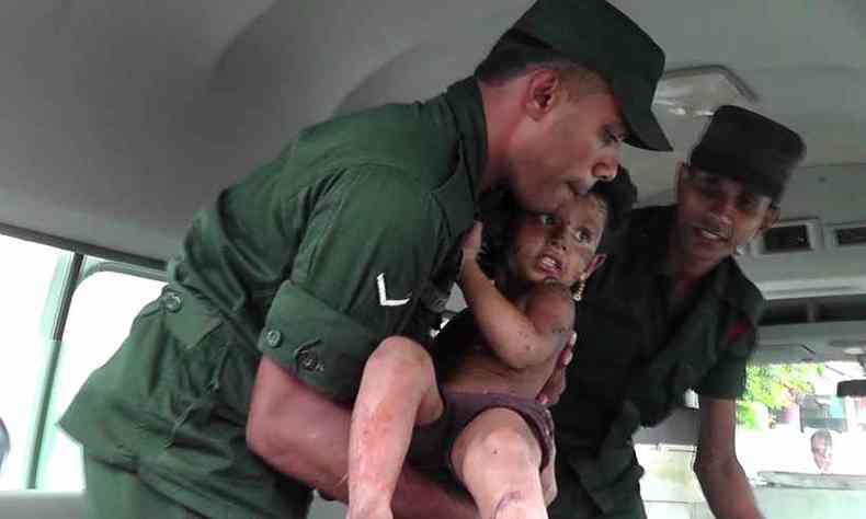 Soldados retiram uma criana ferida aps invadirem uma casa que seria esconderijo de integrantes do Estado Islmico (foto: Stringer / AFP )