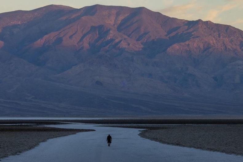Homem caminha pelas salinas ao amanhecer em Badwater, o ponto mais baixo da Am�rica do Norte, em um dia que pode ter novo recorde mundial de calor no Parque Nacional do Vale da Morte 