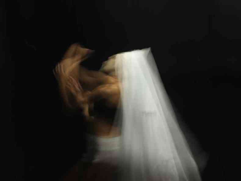 Vestida de branco, a bailarina Vina executa trecho da coreografia de 'Ela', em imagem desfocada