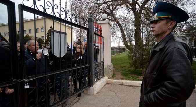 Miiltares de base area ucraniana em Belbek, na Crimeia, enfrentam protestos de ucranianos pr-Russia em seus portes(foto: Filippo MONTEFORTE/AFP)