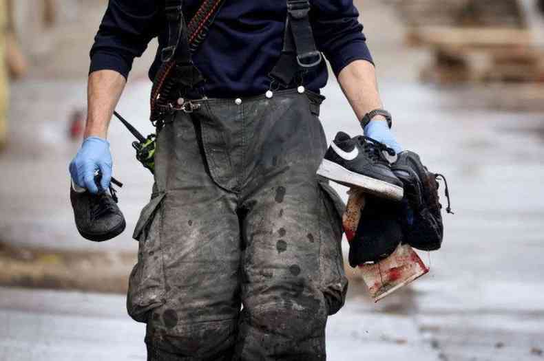 Bombeiro pega sapatos e uma meia ensanguentada aps um tiroteio na garagem de uma empresa de reboque(foto: Scott Olson / Getty Images / AFP)