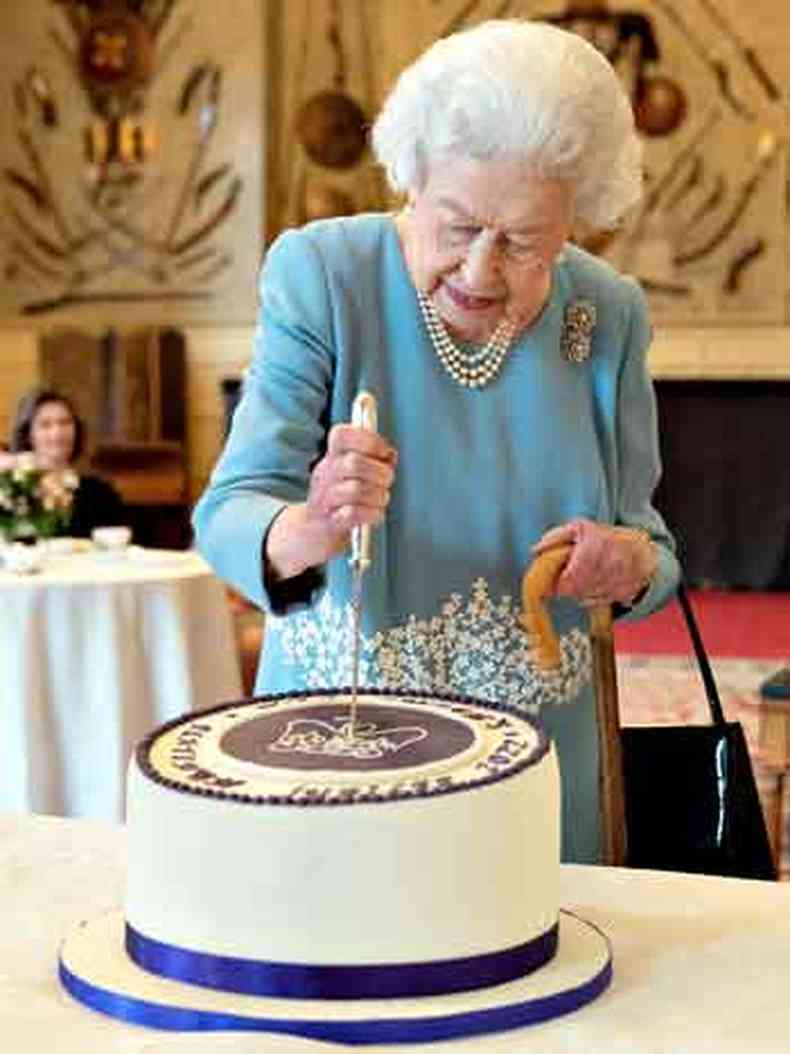 Com vestido azul, Elizabeth II parte o bolo comemorativo do Jubileu de Platina, em sua residncia em Norfolk