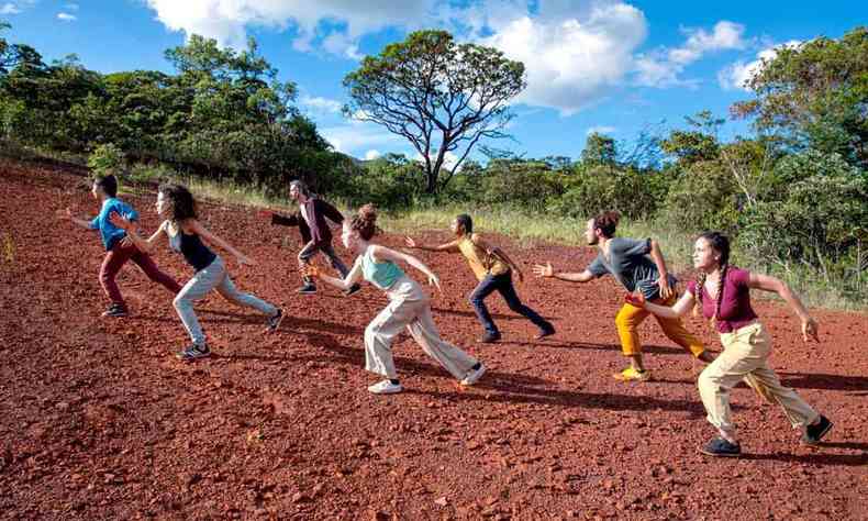 Vestidos com camiseta e cala comprida, bailarinos simulam corrida em piso de terra 