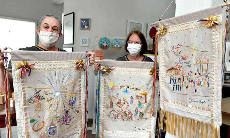 Francisca Paulino Figueiredo e Lda das Graas Costa Ferreira exibem estandartes criados por bordadeiras de Caet