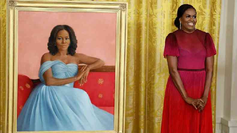 Michelle Obama ao lado de seu retrato oficial na Casa Branca, pintado por Sharon Sprung