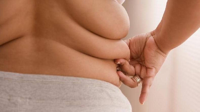 Excesso de peso ainda não é visto por muitas pessoas como uma ameaça imediata à saúde, acredita especialista(foto: Getty Images) Pessoa apertando gordura corporal