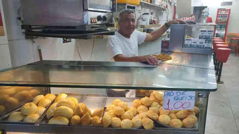 Comerciante em sua lanchonete vendendo po de queijo