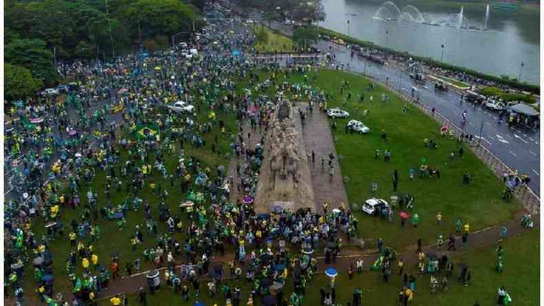 Pessoas com bandeiras do Brasil e camisas amarelas em gramado e avenidas vizinhas ao lago do Ibirapuera