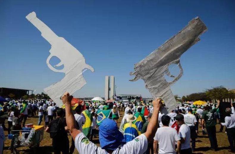 Homem com armas de papelo em comcio