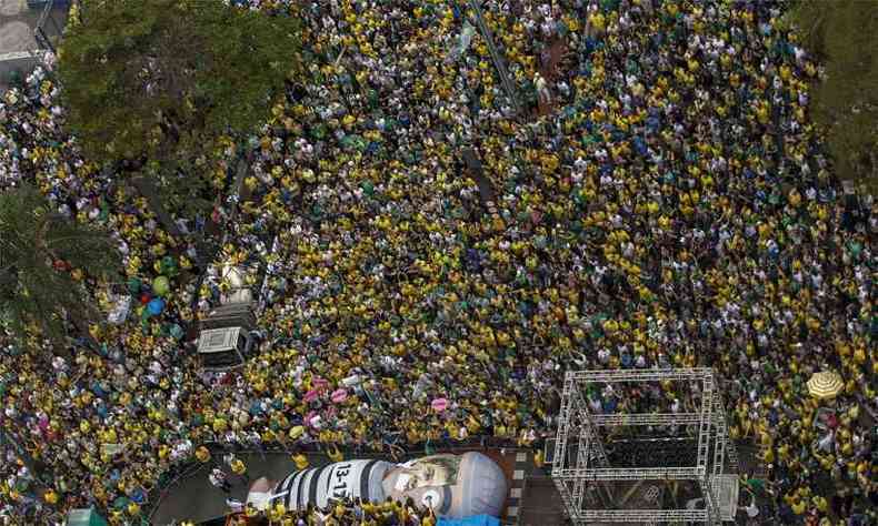 Manifestantes pr-Bolsonaro na Avenida Paulista. Protesto conta com um 'Pixuleco' gigante com metade do rosto do candidato do PT, Fernando Haddad(foto: Miguel SCHINCARIOL / AFP )
