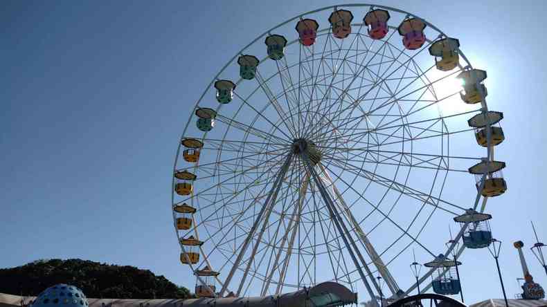 Roda gigante com o cu azul ao fundo. 