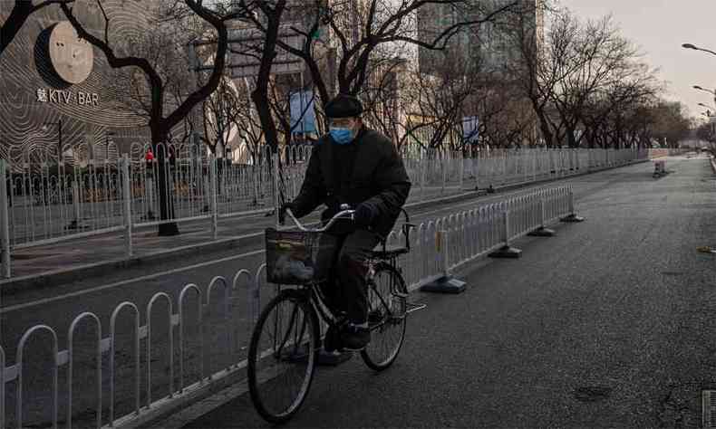 Homem pedala pelas ruas desertas de Wuhan, cidade onde o surto do coronavrus comeou(foto: NICOLAS ASFOURI / AFP)