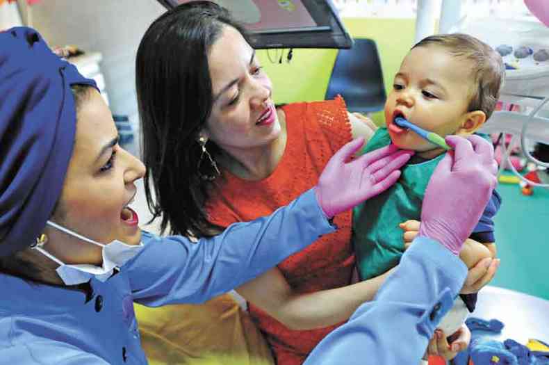 A odontopediatra Gabriela Lopes com o pequeno Luiz Otvio e a me, Taise: ida ao dentista assim que surgiu o primeiro dente