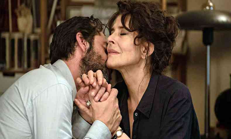 Os atores Fanny Ardant e Melvil Poupaud se beijam em ambiente a contraluz em cena do filme Jovens amantes 