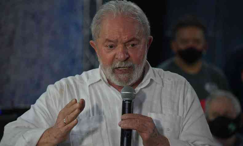 O ex-presidente Lula segura microfone e gesticula durante discurso
