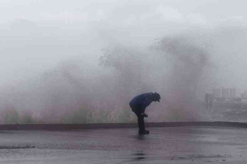 Furaco Dorian j agita as guas da costa sudeste dos EUA. Em Jensen Beach, na Flrida, um reprter de TV foi atingido por ondas provocadas por fortes rajadas de vento (foto: ADAM DELGIUDICE/AFP)