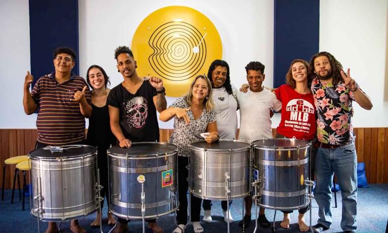 Di Souza ( direita) com alunos posando com tambores