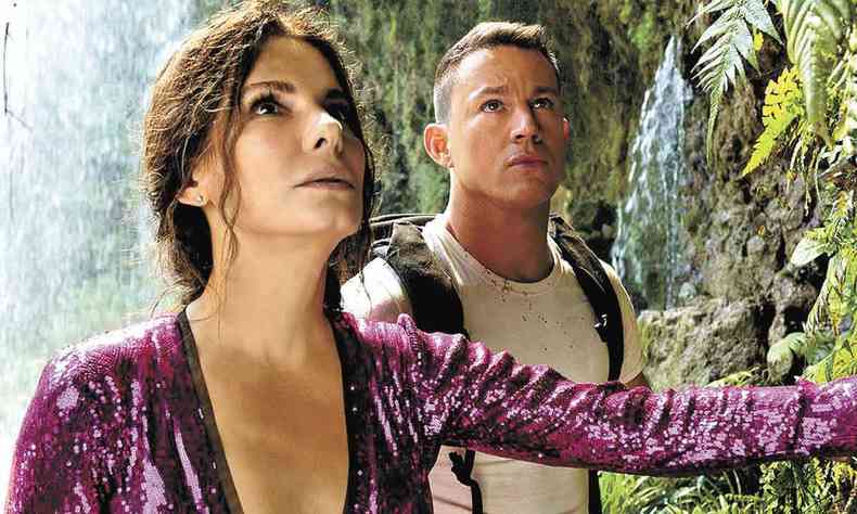 Sandra Bullock, com roupa de lantejoulas roxas, e Channing Tatum contracenam no meio do mato durante o filme Cidade perdida