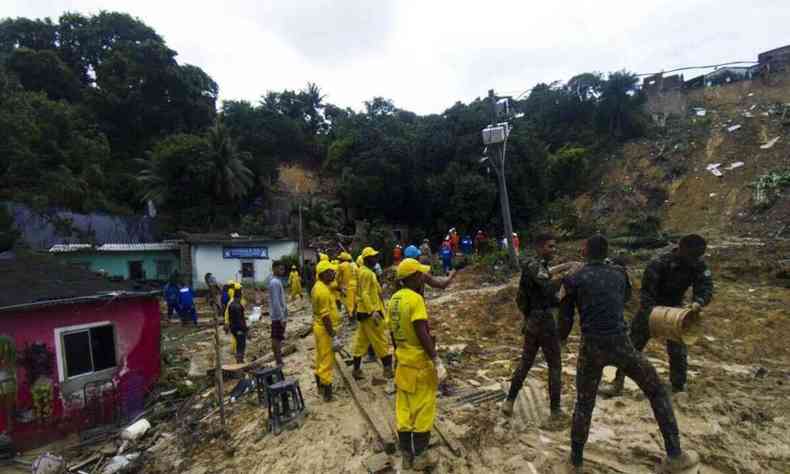 Trabalhadores da Defesa Civil em rea de deslizamento de terra