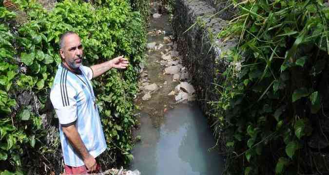 Lder comunitrio do Bairro Vila Prola, em Contagem, Renato Gherardi mostra esgoto lanado em crrego que chega  lagoa  espera de saneamento.(foto: Paulo Filgueiras/EM/D.A Press)