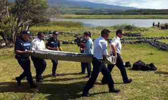 Policiais carregam destroos da aeronave encontrados em julho(foto: YANNICK PITOU)