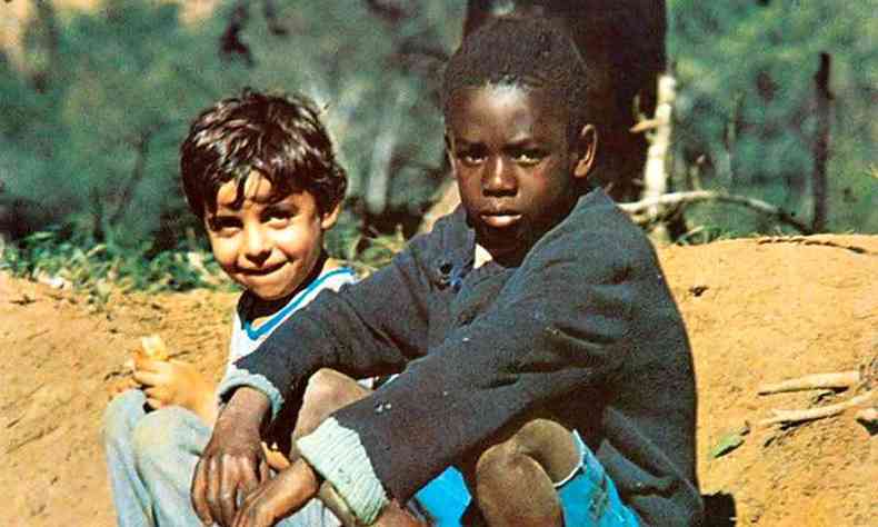 Capa do lbum 'Clube da Esquina' traz foto de garotos branco e negro sentados  beira da estrada