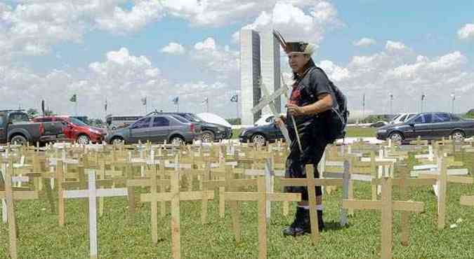 Rose Cabrera Kaiow e Elizeu Lopes Guarani- Kaiow colocam cruzes, simbolizando os mortos, marcando o protesto em frente ao Congresso Nacional(foto: Wilson Dias/ABr)