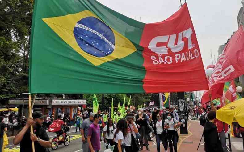 Manifestantes seguram bandeira do Brasil e da CUT