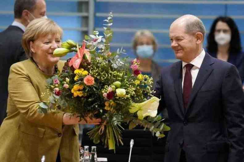 Angela Merkel recebe buqu do vice-chanceler e seu sucessor, Olaf Scholz, antes da ltima reunio de gabinete da lder conservadora