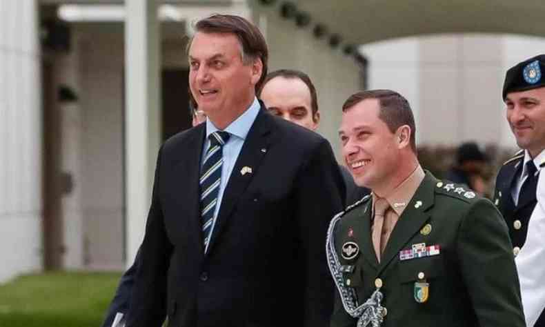 Mauro Cid e Bolsonaro; ambos sorriem