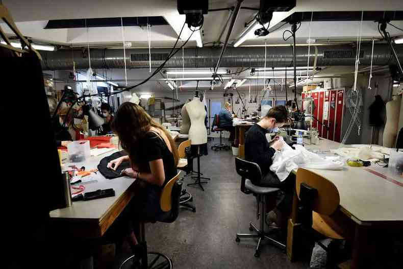 Mulheres costuram em mquinas industriais