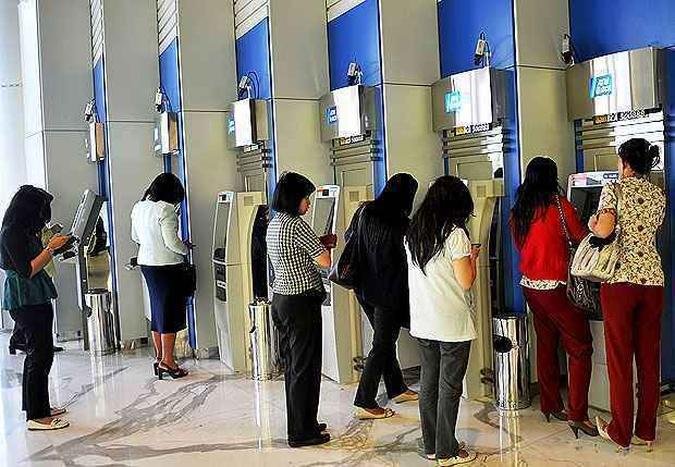 Indon�sias s�o vistas em caixas eletr�nicos na cidade de Jacarta(foto: ADEK BERRY / AFP)